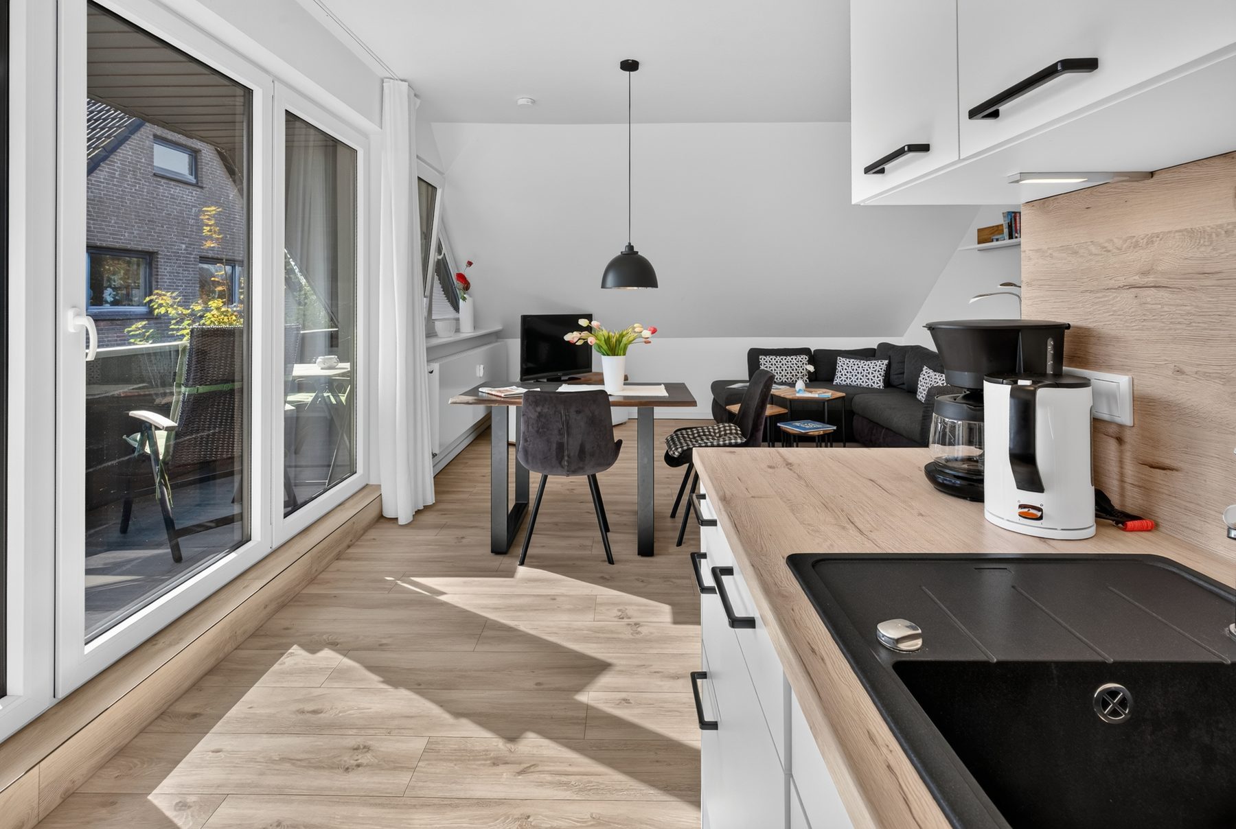 Wohnküche der Ferienwohnung 2 auf Norderney mit Blick zu den Loggia-Türen